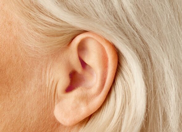Close-up of female ear. Senior model. Hearing problems and health care, deafness, health check up